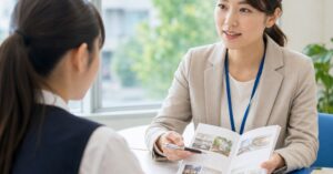 高崎のスクールで入学相談を受け、学習内容や費用について説明を聞く学生